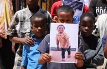 بعض أطفال الحي الذي يسكن فيه الطفل سيد أحمد يرفعون صوره أمام منزله